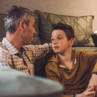 Parent and child inside house having a conversation.