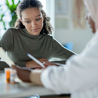 Teenager consulting with a doctor about medicine