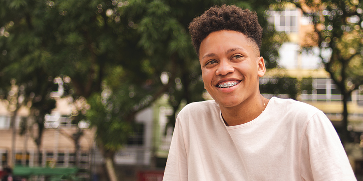 Teenage boy smiling and looking to the side.