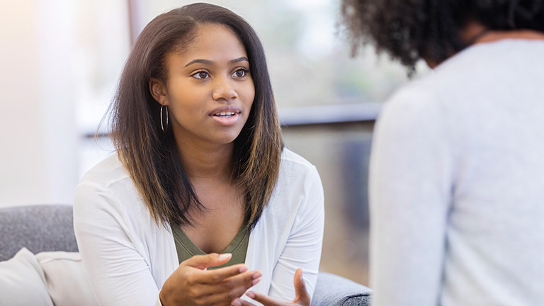 Female teenager talking with a doctor.