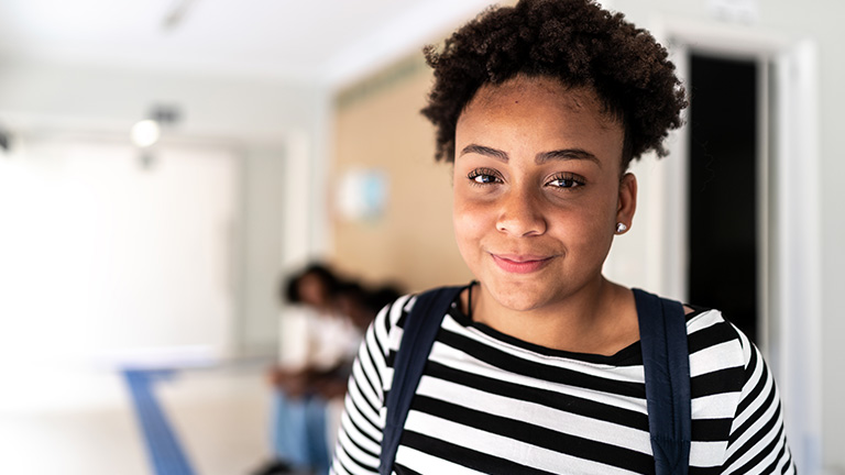 Female teenager wearing a striped shirt smiling.