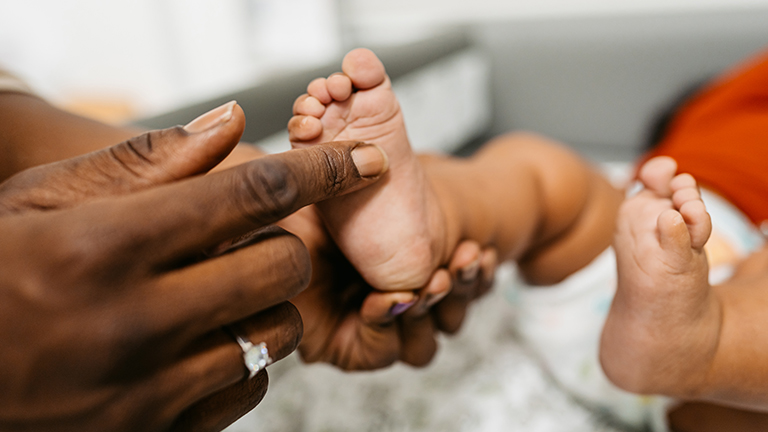 Mother touching the bottom of her childs foot.